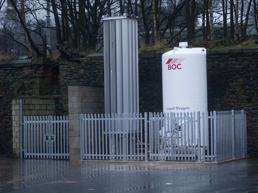 Galvanised steel palisade fencing and gates enclosing a bulk gas storage tank compound