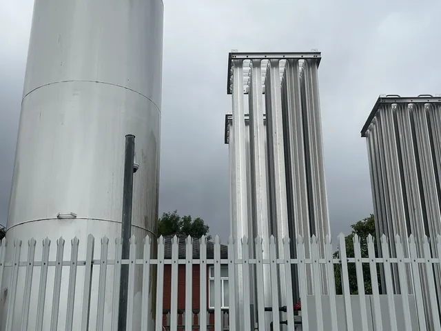 Galvanised palisade fencing around industrial storage tanks